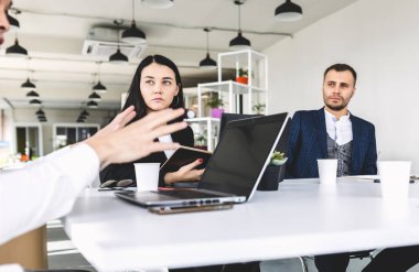 Ofis masasında iş arkadaşlarıyla otururken çalışan ve iletişim kuran bir grup genç iş adamı. iş toplantısı