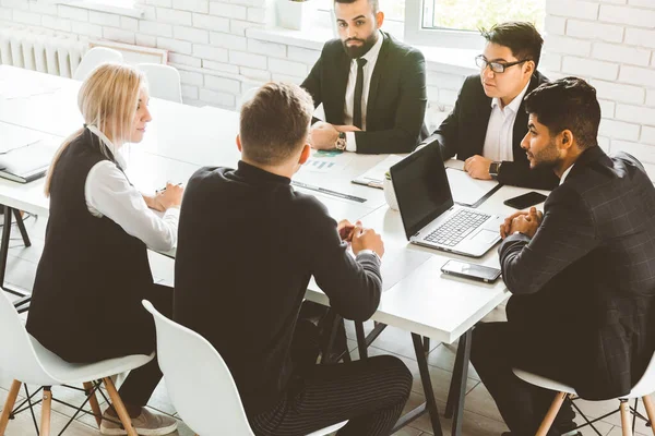 Un equipo de jóvenes empresarios que trabajan y se comunican en una oficina. Corporativossteam y gerente en una reunión. — Foto de Stock