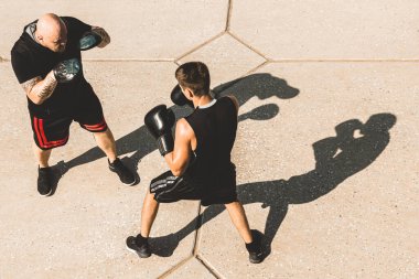 Dışarıda egzersiz yapan ve kavga eden iki adam. Eldivenli boksör antrenman yapıyor.