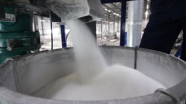 Ένας εργαζόμενος συσκευάζει χύμα πρώτες ύλες από αυτόματο μίξερ σε βαρέλια και σακούλες στο εργοστάσιο. Παραγωγή προϊόντων από πολυπροπυλένιο — Αρχείο Βίντεο
