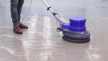 Temizlikçi rıhtımı profesyonel bir cilalama makinesiyle yıkıyor. Ofis binasının zeminini temizliyorum.