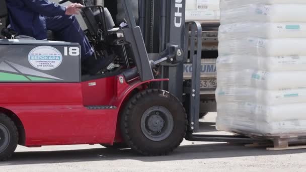 Ufa, Rusya, 30 Haziran 2020. Polipropilen üretim tesisi. Forklift kullanan bir adam büyük bir depoda çalışır ve bir çanta dolusu hammaddeyi boşaltır. — Stok video