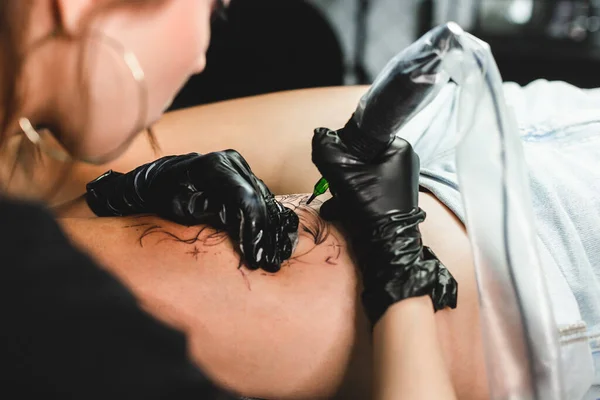 전문적 인 여성 문신 예술가 가 스튜디오에서 문신을 완성 합니다. 어두운 사진 — 스톡 사진