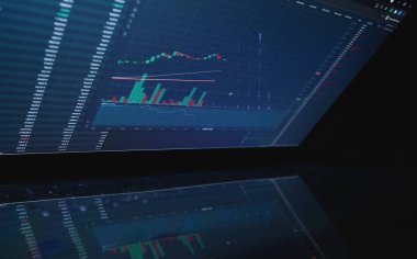 Borsa çizelgeleriyle dizüstü bilgisayar ekranı. Teknik analiz ve ticaret terminalindeki hisse senetlerinin temel göstergeleri. Japon şamdanları ve şirket saatleri..