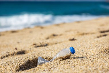 Gezegenin çöp kirliliği. Plaj kumsalında boş plastik şişe. İnsan yaşamının sonuçları.
