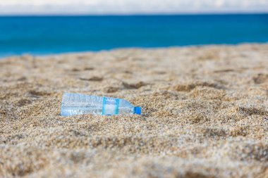 Gezegenin çöp kirliliği. Plaj kumsalında boş plastik şişe. İnsan yaşamının sonuçları.