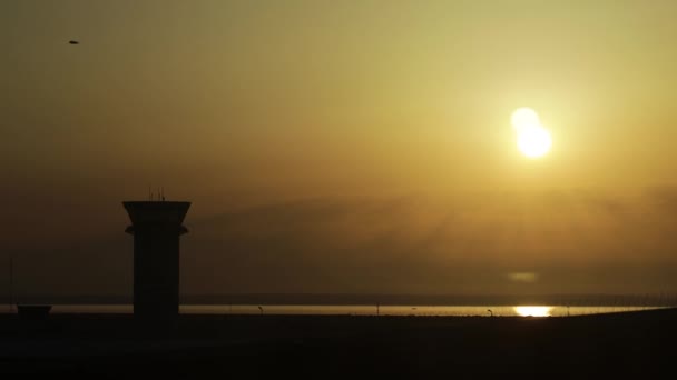Poranne słońce wschodzi na lotnisku na tle wieży kontrolnej — Wideo stockowe