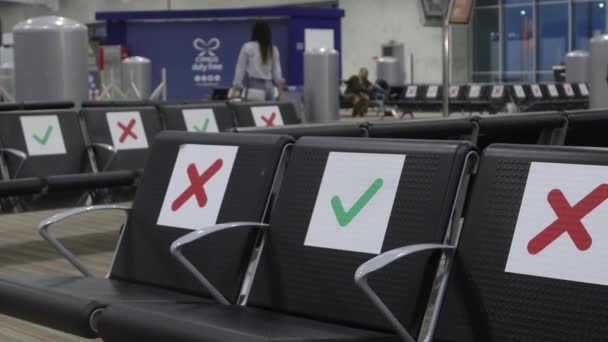 Airport during the Covid-19 pandemic. The rising sun in the morning illuminates the empty departure and waiting area from a chair with special social distancing signs — Stock Video