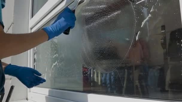 Profesionální mužský pracovník v montérkách obratně čistí okna speciálními chemikáliemi zblízka — Stock video
