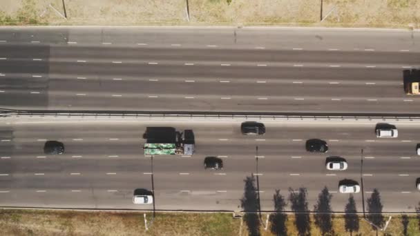 View from the top to the highway. 4K aerial drone shooting of a multi-lane road with moving vehicles. Car traffic in a big city — Stock Video