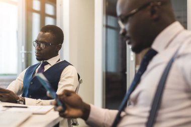 Afrika kökenli Amerikalı bir iş adamının iki esmer ortağı ofiste dizüstü bilgisayarla iş yapıyorlar. Uygun fiyatlı özel kurslar ve uzaktan öğrenme. İnternette yeni fırsatlar