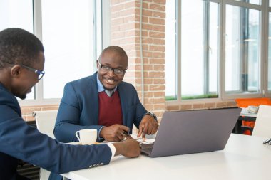 Afrika kökenli Amerikalı bir iş adamının iki esmer ortağı ofiste dizüstü bilgisayarla iş yapıyorlar. Uygun fiyatlı özel kurslar ve uzaktan öğrenme. İnternette yeni fırsatlar