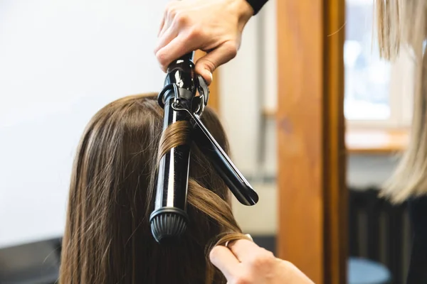 Cabeleireiro mulher mestre suavemente cachos cabelo curling menina em um salão de beleza. Estilo de cabelo — Fotografia de Stock