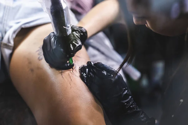 Kadın dövme sanatçısı stüdyoda dövme yapıyor, vücudunda dövme yapıyor. Yakın çekim — Stok fotoğraf