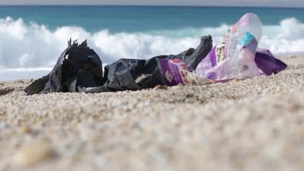 Забруднення сміття планети. Пластик та інші сміття на пляжному піску. Наслідки людського життя — стокове відео