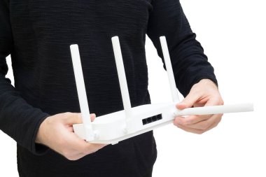 Modern çift bantlı Wi-Fi 6 modem tutan ve antenlerden birini işaret eden bir adam. Optimum konumlandırma yoluyla kapsama ve sinyal iyileştirilmesi.