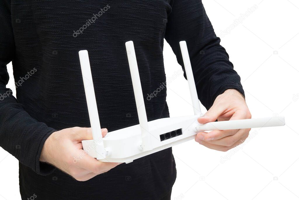 Man holding a modern dual band wi-fi 6 router and pointing one of of the antennas. Improving coverage and signal through optimal positioning.