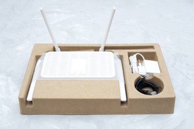 Son nesil çift bantlı Wi-Fi 6 yönlendirici. Beton bir masanın üstündeki perakende kutusunda dört anten var..