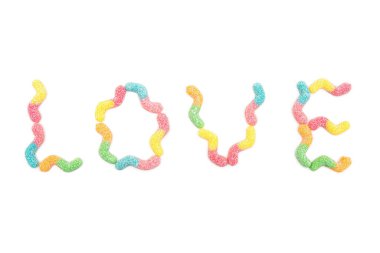 Aşk kelimesi beyaz arka planda izole edilmiş çok renkli jelibon solucanlarından yapılmış.