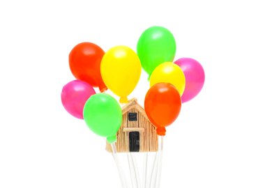 Beyaz arka planda izole edilmiş çok renkli balon kümesindeki küçük ev modeli. Yaratıcı emlak konsepti.