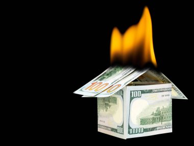 Yanan yüz dolarlık banknotlardan yapılmış bir ev. Yangın sigortası kavramı.