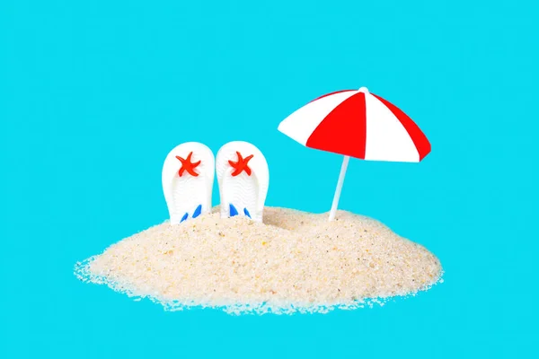 毛茸茸的太阳伞和白色的翻筋斗从蓝色背景中隔离的沙堆中伸出 模仿水 创意海滩度假概念 — 图库照片
