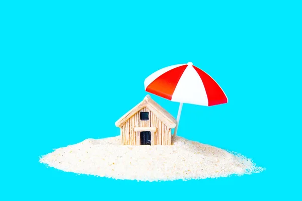 Миниатюрный Игрушечный Домик Зонтиком Куче Песка Изолированного Голубом Креативная Концепция — стоковое фото