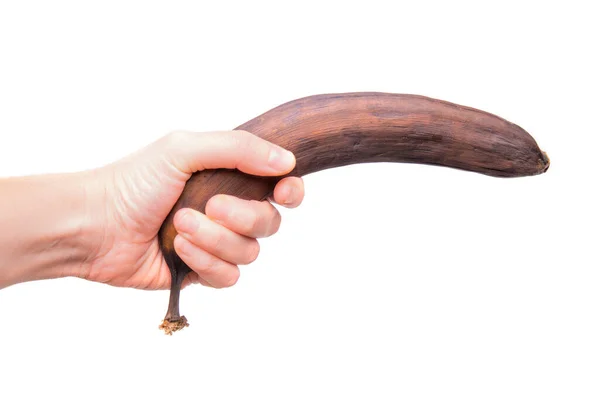 白地に隔離された褐色のバナナを持つ女性の手 — ストック写真