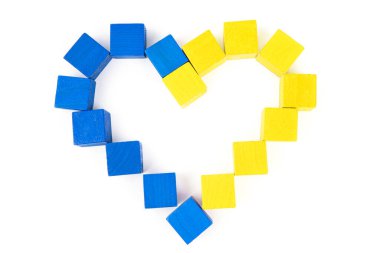 Tahta bloklardan yapılmış kalp sembolü beyaza izole edilmiş Ukrayna bayrağının renklerini boyadı. Yaratıcı vatanseverlik kavramı.