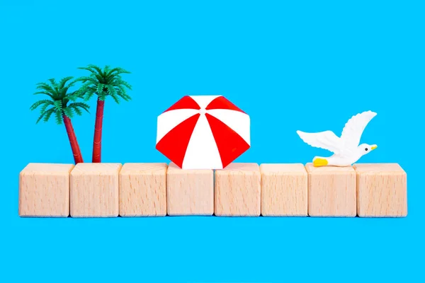 带棕榈树 阳伞和木制玩具块的夏季海洋度假构图 与蓝色隔离开复制空间 — 图库照片