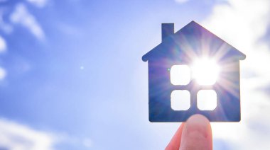 Mavi gökyüzüne karşı güneş ışığında düz ahşap bir ev..