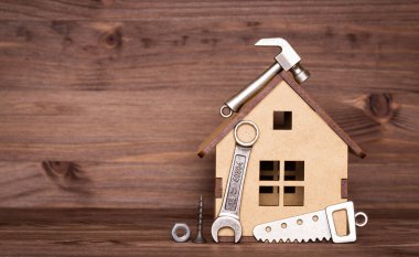 Oyuncak kontrplak paneli ve ahşap arka planda fotokopi alanı olan popüler iş araçları ve bağlayıcıların küçük kopyaları.