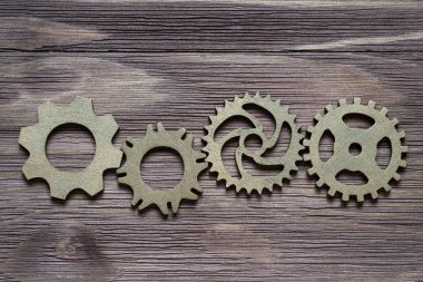 Ahşap bir arka planda küçük vitesler. Yaratıcı mantık kavramı.