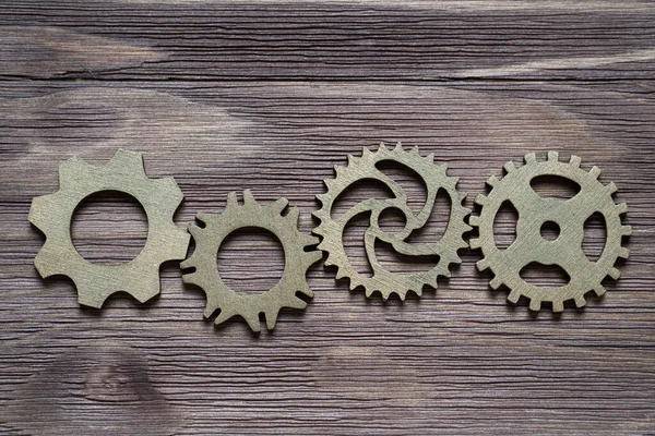 Ahşap bir arka planda küçük vitesler. Yaratıcı mantık kavramı.