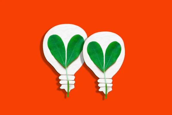 Two Flat Lightbulb Shapes Fresh Sprouts Isolated Red Background Green — стоковое фото