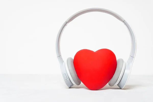 Ασύρματα Ακουστικά Πάνω Από Ένα Μεγάλο Κόκκινο Σχήμα Καρδιάς Απομονώνονται — Φωτογραφία Αρχείου