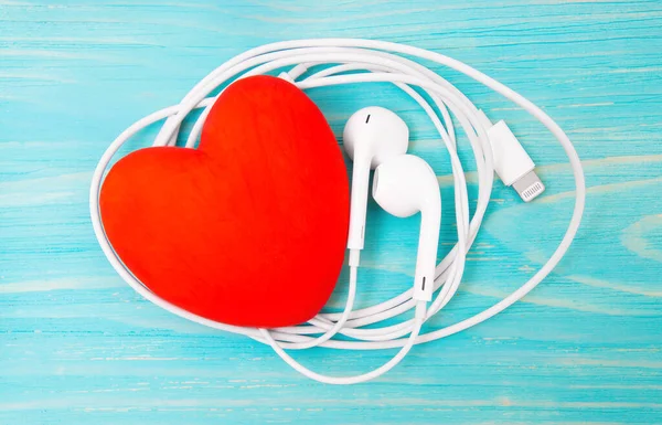 Μεγάλη Κόκκινη Καρδιά Και Λευκά Ακουστικά Μπλε Ξύλινο Φόντο Μουσική — Φωτογραφία Αρχείου