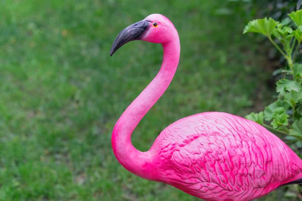 在草坪背景下对粉红火烈鸟院子雕塑的特写 — 图库照片