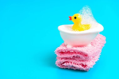 Sarı oyuncak ördek sabunlu bir banyo yapıyor. Banyo oyuncakları temizlik konsepti.