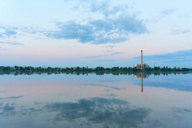 Şehirdeki atık yakma tesisinin göl manzarası.