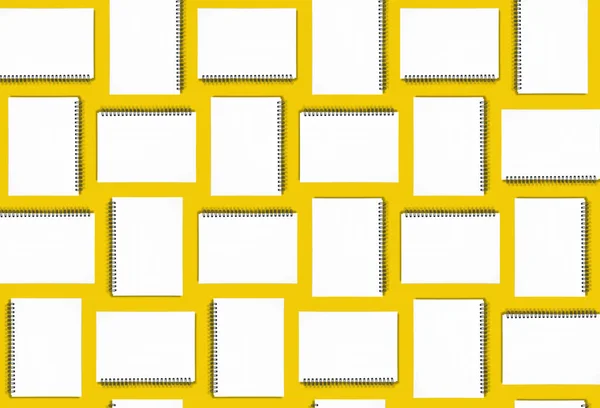 Abstract education background: spiral notebooks on yellow.