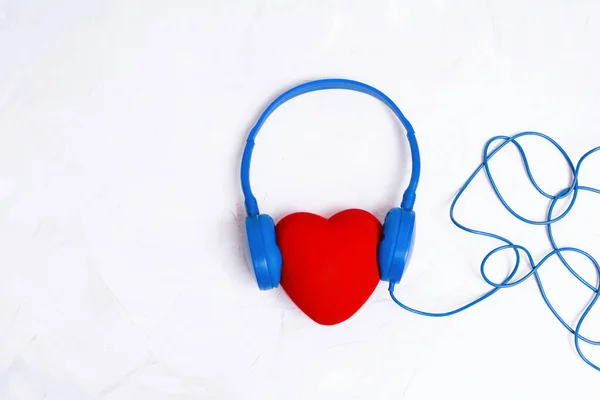 Ενσύρματα Ακουστικά Πάνω Από Ένα Μεγάλο Κόκκινο Σχήμα Καρδιάς Που — Φωτογραφία Αρχείου
