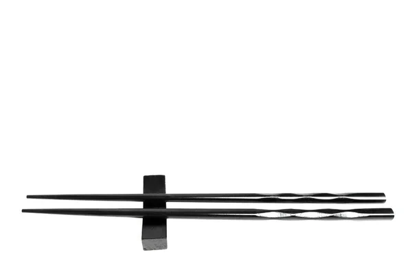 Pair Black Lacquered Chopsticks Placed Elevated Rest Isolated White Background — Zdjęcie stockowe