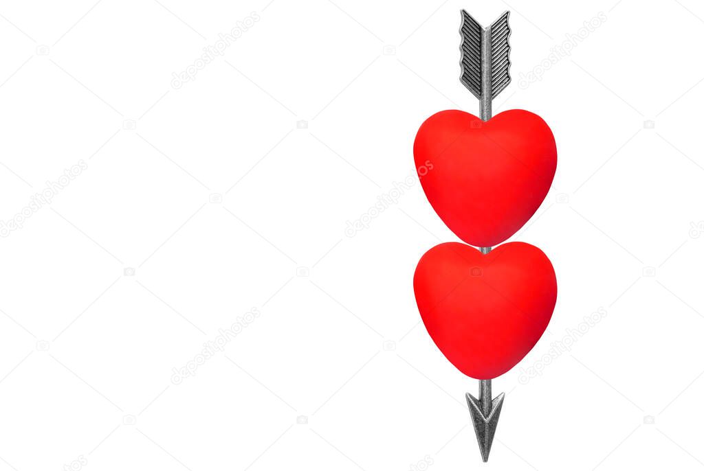 Feathered bow arrow running through two red hearts isolated on white background.
