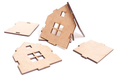 Wooden toy house elements scattered on white background