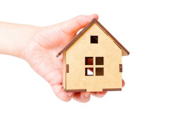 Assembled model kit house in hand isolated on white background. Real estate investment concept.