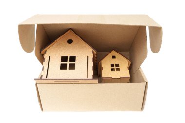 Two wooden toy houses inside a shipping box. Real estate investment concept.