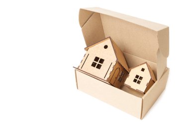 Assembled toy houses in a cardboard box isolated on white. Home relocation service concept.