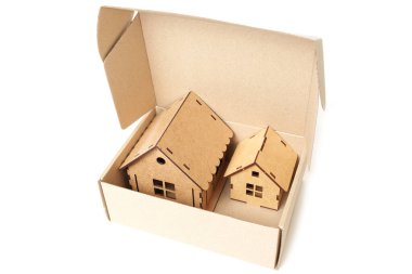 Small cardboard box with two toy houses inside. House trade in program concept.