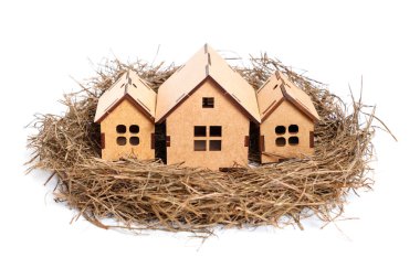 Bird's nest with three self-assembly wooden houses isolated on neutral background. Safe residential housing concept.